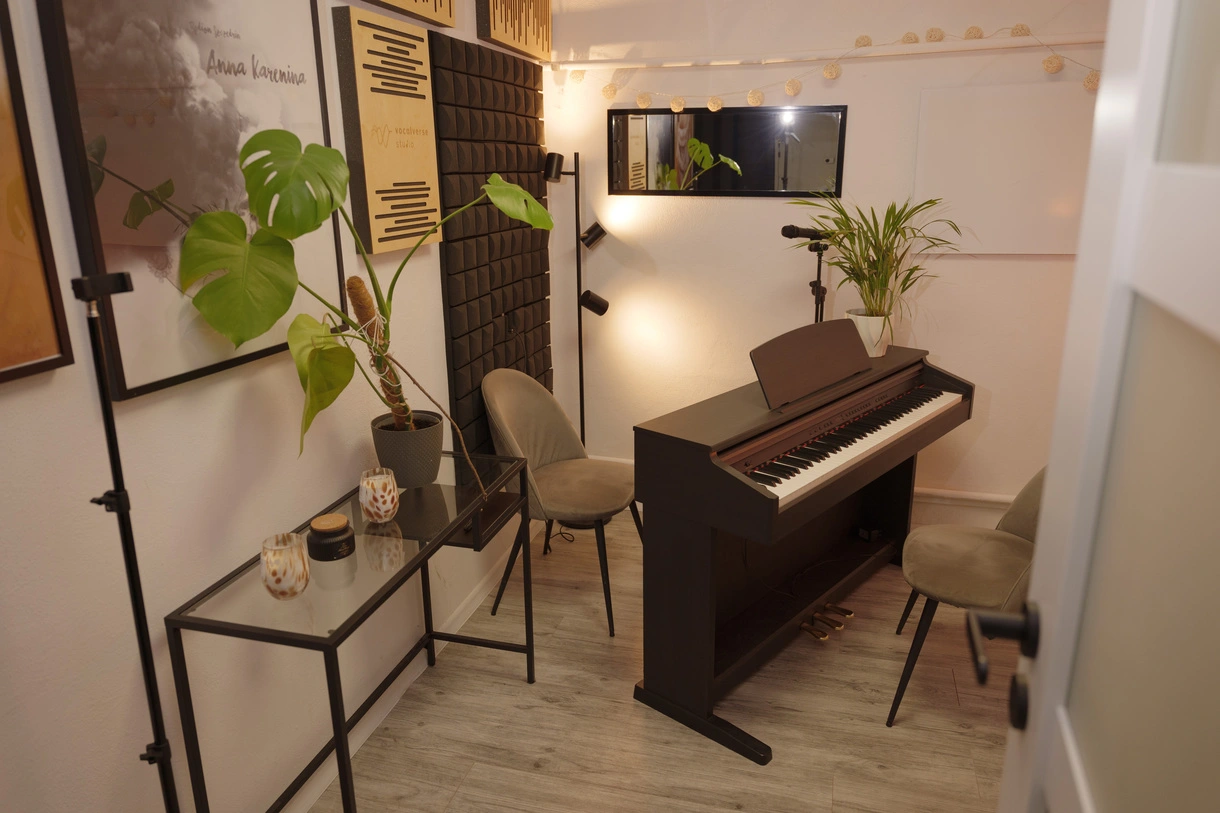 Sala druga - szara, z pianinem, mikrofonem, nagłośnieniem, dwoma krzesłami, konsolą, kwiatkami oraz obrazami naścianie. Lustro dla wokalisty.